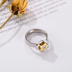 Detailed macro view of two-tone flower ring with a clear zircon stone on textured paper