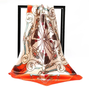 Detailed close-up of vintage satin scarf featuring chain patterns and jewel prints