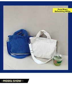 Détail de la texture velours côtelé des sacs cabas bleu et blanc avec bandoulière