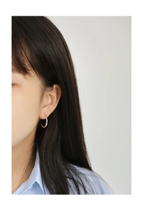 Close-up of minimalist silver hoop earrings worn by a model for a stylish casual look