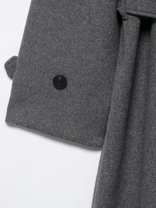 Close-up of gray wool coat showing fabric texture and a polished black button detail