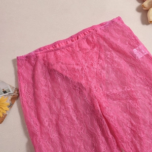 Détail du pantalon en dentelle transparente rose avec des motifs floraux délicats