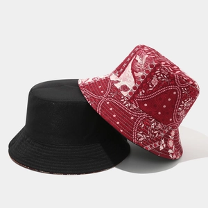 Dettaglio del cappello a secchiello reversibile in cotone nero con stampa paisley rossa
