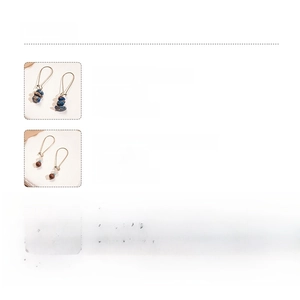 Détail de boucles d'oreilles vintage avec perles en agate et pin impérial sur fond blanc