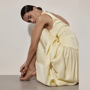 Détail d'une élégante robe longue en satin dos nu jaune pâle avec une coupe ajustée