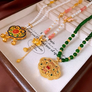Detail of Chinese style necklaces with pearls, agate beads, and golden Ruyi lock pendants