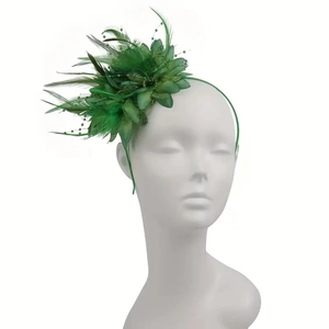 Detail of green fascinator headband with delicate feathers and elegant beadwork on a model