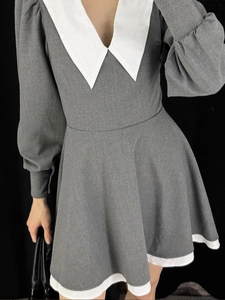 Detail of grey dress with large white V-shaped doll collar and lantern sleeve cuffs
