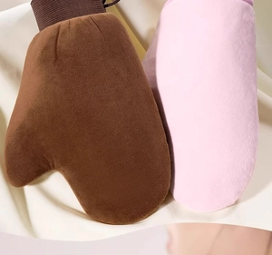 Detailed macro view of soft velvet tanning mitts in brown and pink with thumb design