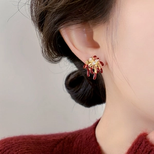 Detail of 18k gold plated firework earrings with red enamel and sparkling zircons