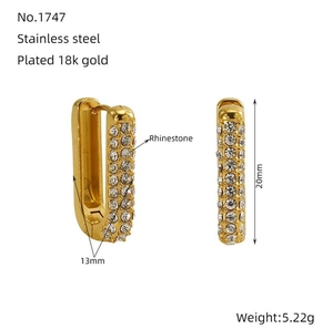 Detail view of U-shaped gold earrings with 18K plating, cubic zirconia, and 20mm size