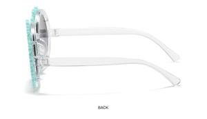 Detail view of mint green daisy flower sunglasses with transparent temples and embossed decor