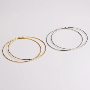 Flat lay of 100mm minimalist gold and silver large hoop earrings in stainless steel