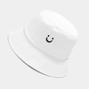 Close-up of white cotton bucket hat with black embroidered smile face and reinforced stitching