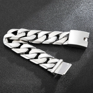 Macro detail of 24mm wide stainless steel Cuban link bracelet with a polished finish