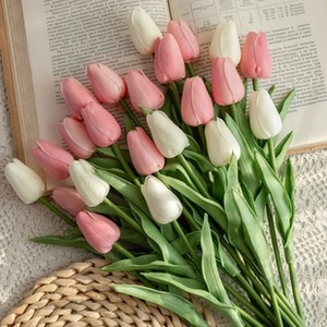 Detailed close-up of pink and white artificial Calla Lilies placed on an open book