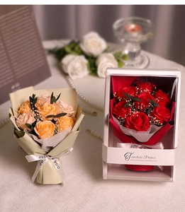 Macro shot of artificial soap roses in gift boxes with romantic decorative candles