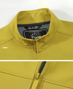 Detail of waterproof zipper and stand collar on a bright yellow outdoor softshell jacket