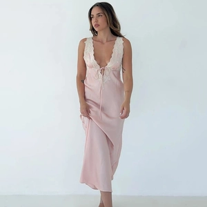 Détail de la robe en satin rose avec dentelle crème et décolleté en V profond