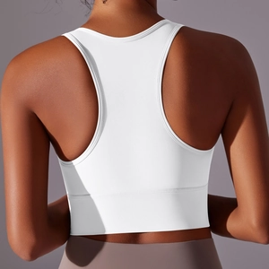 Detail of white racerback sports bra showing elastic wide hem and high-stretch fabric