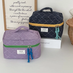 Detail of quilted checkered makeup bags with colorful zippers and decorative tassels
