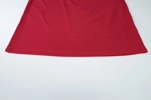Détail de l'ourlet de robe rouge montrant une couture à double aiguille de haute qualité