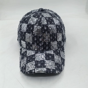 Detail of silver sequin checkerboard pattern on distressed denim baseball cap