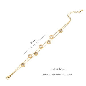 Détail du bracelet double couche en acier doré avec breloques étoile et zircon