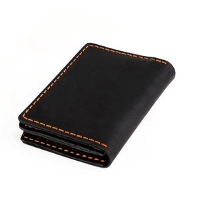 Detail of crazy horse leather wallet with contrasting orange stitching and matte texture
