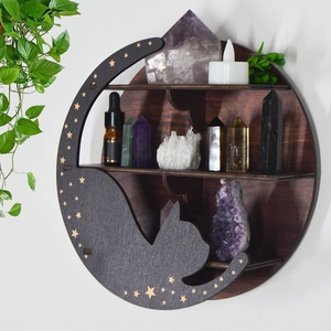 Detailed view of bohemian moon cat wooden shelf with crystals and oils on white wall