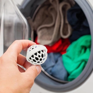 Close-up of a white purse cleaning ball removing dust and debris inside a handbag