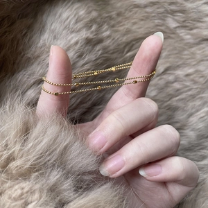 Minimalist double-layered 18K gold-plated stainless steel star bead bracelet on fur background