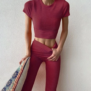 Dettaglio del tessuto in maglia a coste rosso scuro del set crop top e pantaloni