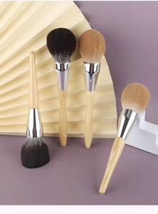 Macro shot of fluffy powder brushes with bionic hair and polished solid wood handles