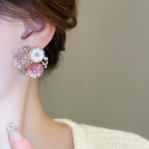 Close-up of sweet pink and white flower earrings with crystal center on female model