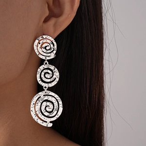 Vue rapprochée de boucles d'oreilles spirales argentées avec texture martelée