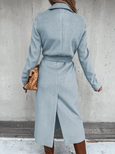 Detail view of the light blue wool coat featuring a belted waist and back slit detail