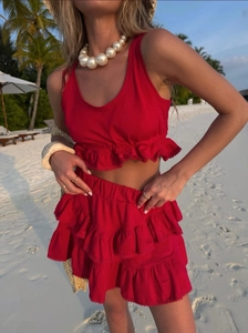 Detail of red tiered lace ruffle skirt and crop top in a tropical beach setting