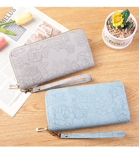 Detail of floral embossed texture on long leather wallets with secure gold zippers