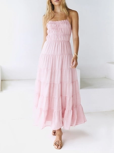 Full-body model view of a pink halter neck pleated tiered maxi dress on a white background