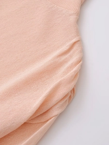 Gros plan détaillé du tricot fin pêche avec texture de cordon de serrage froncé latéral