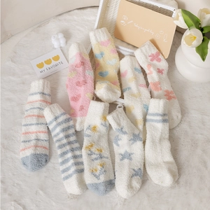 Detailed texture of thick coral fleece socks in pastel colors on a cozy white rug
