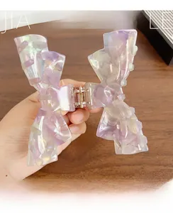 Detailed view of large marble pattern acetic acid bow hair claw with purple finish