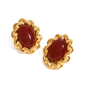 Detailed close-up of vintage gold twisted rope earrings with red onyx gemstone inlays