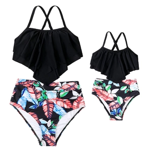 Matching mother daughter tankini sets with black ruffle tops and tropical palm leaf bottoms