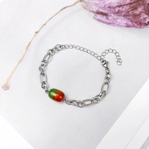 Détail d'un bracelet en chaîne d'acier inoxydable avec perle d'agate en dégradé vert et orange
