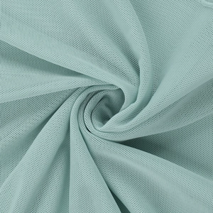 Détail macro du tissu en maille vert menthe avec texture alvéolée et drapé doux