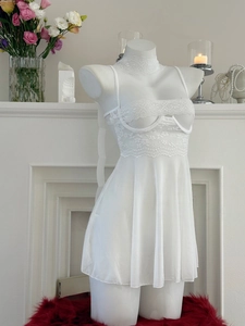 Dettaglio di un set di lingerie in pizzo bianco con scollo all'americana su un manichino