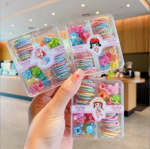 Detailed set of colorful elastic hair bands and cute plastic clips in clear gift boxes