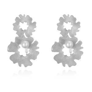 Macro detail of silver flower earrings with textured petals and inlaid central pearl